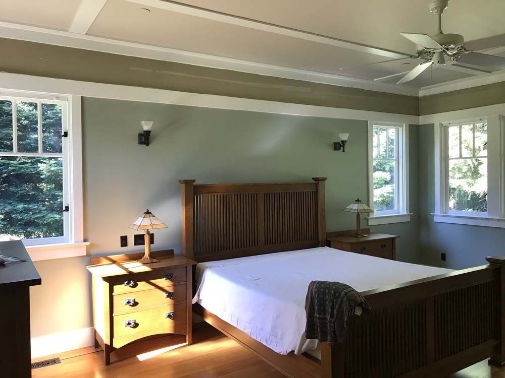 A bedroom with a bed , two nightstands , and a ceiling fan.
