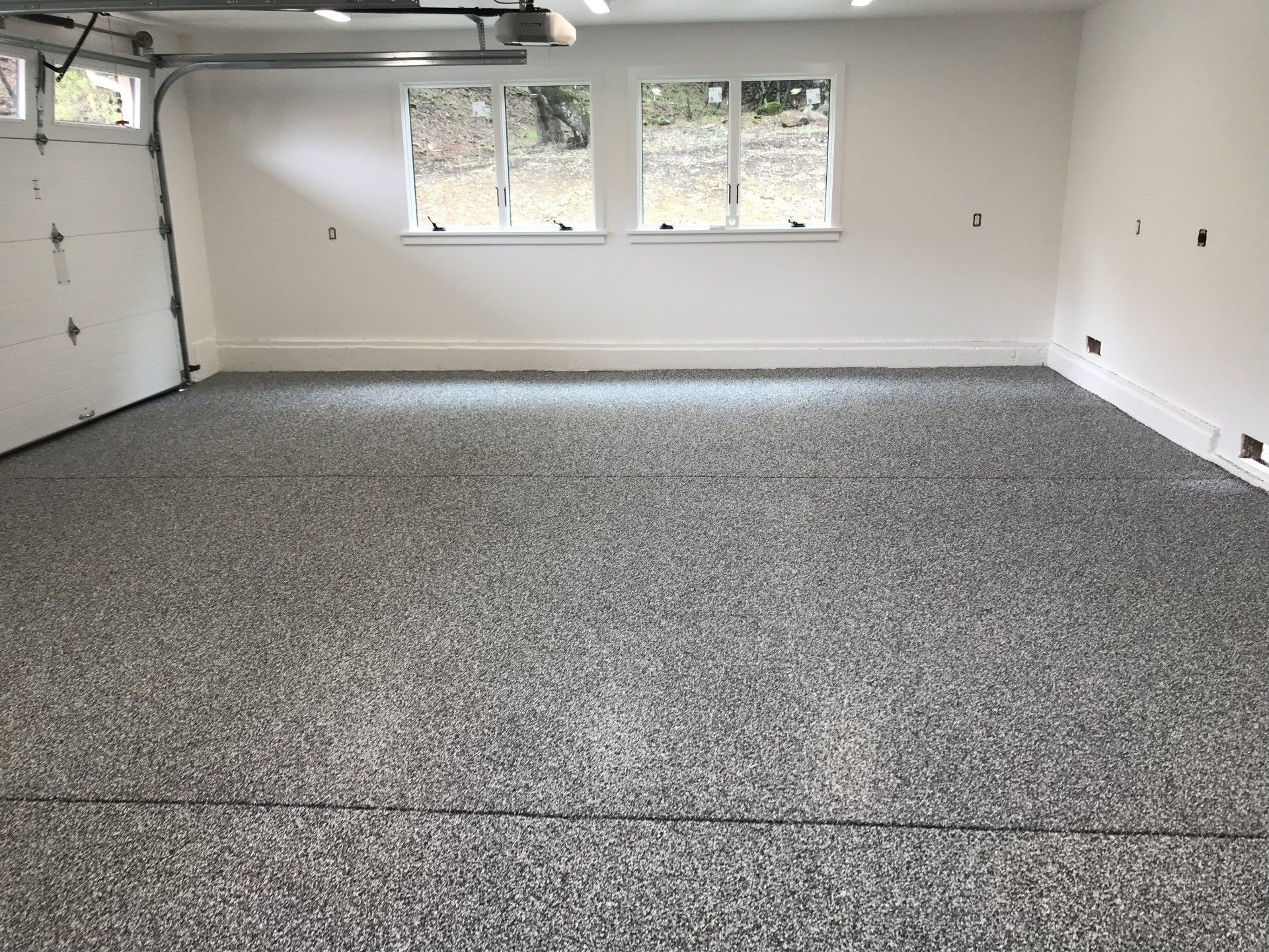 A garage with a gray floor and white walls.