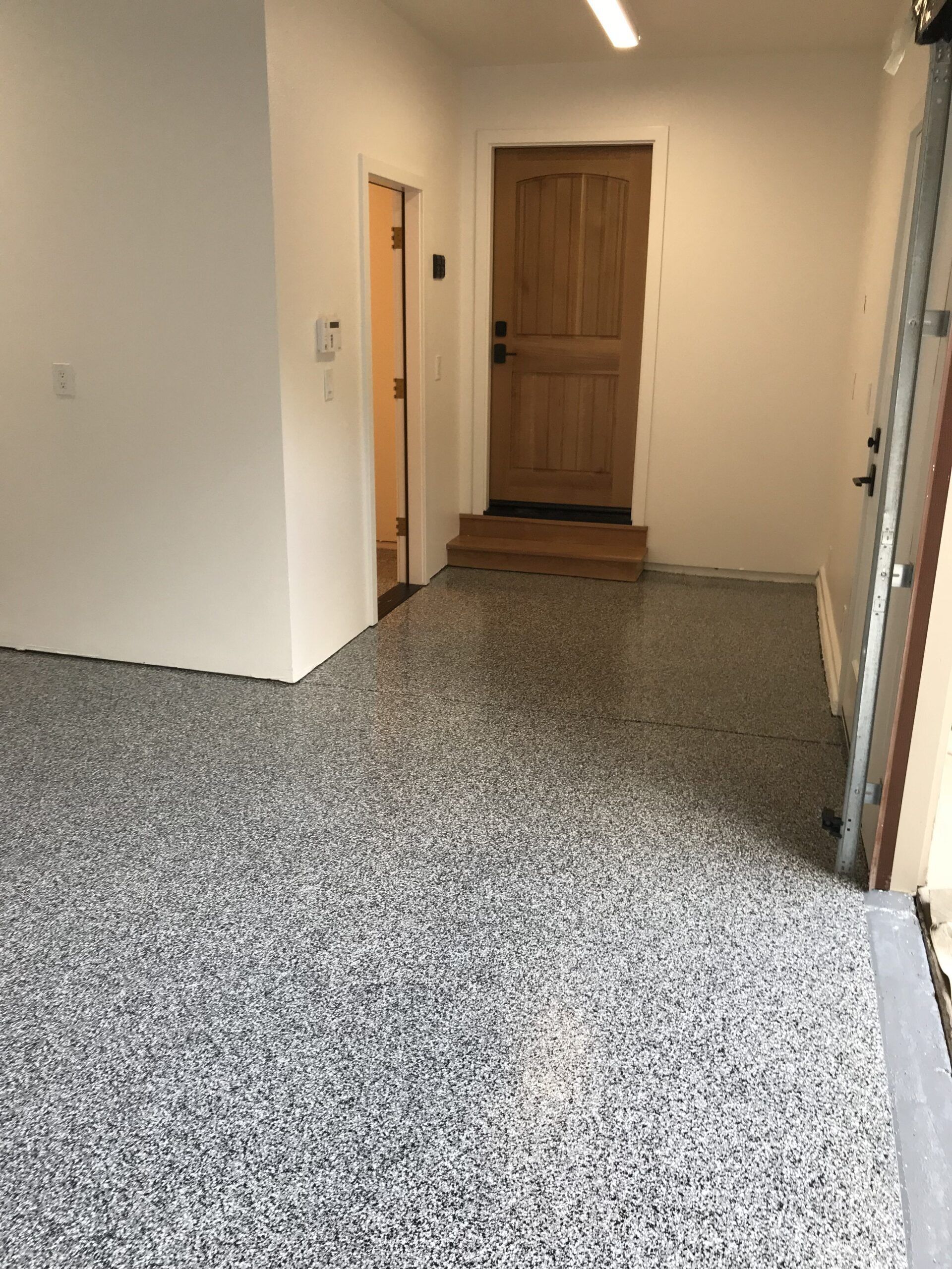 A room with a carpeted floor and a door.