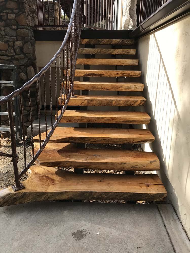 A wooden staircase with a metal railing leading up to a building.