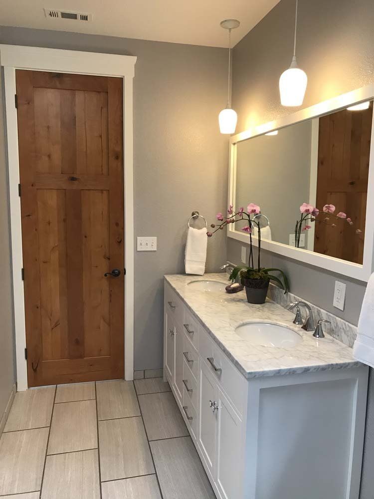 A bathroom with two sinks and a large mirror