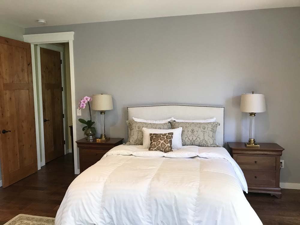 A bedroom with a bed , two nightstands and two lamps