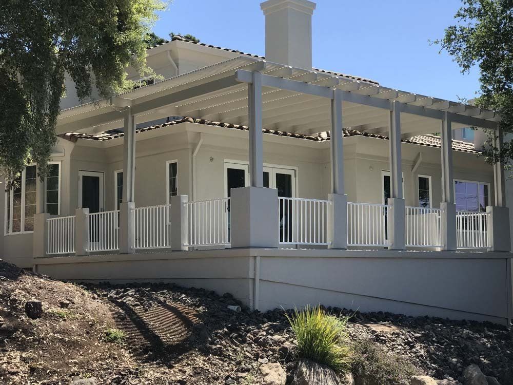 A white house with a large porch and a white railing