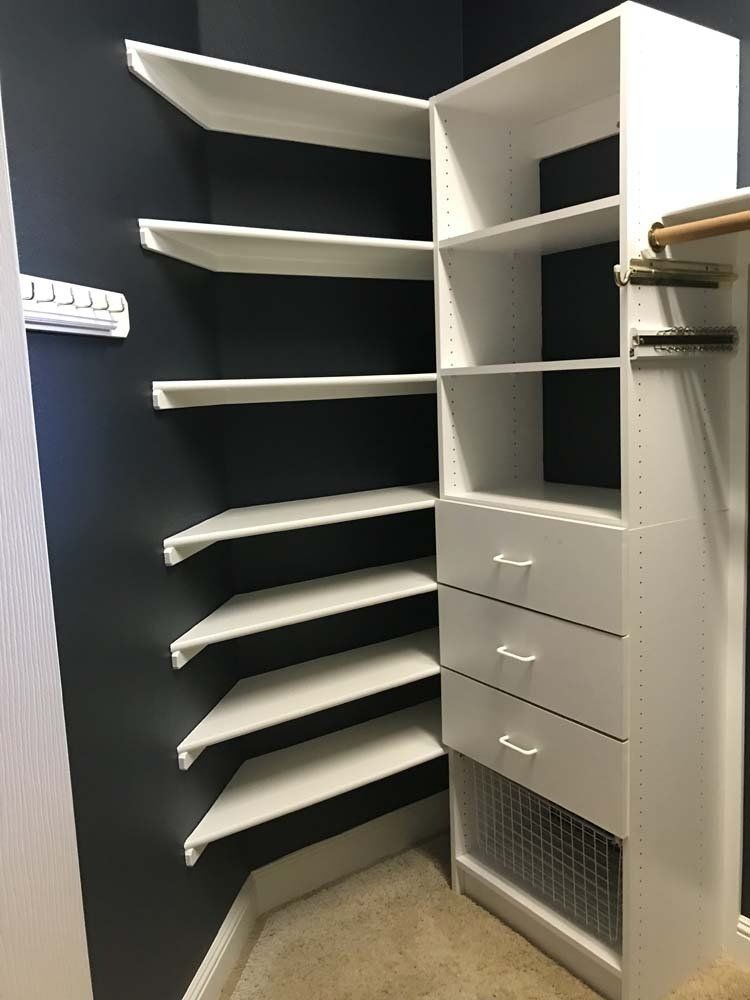 A walk in closet with lots of shelves and drawers.