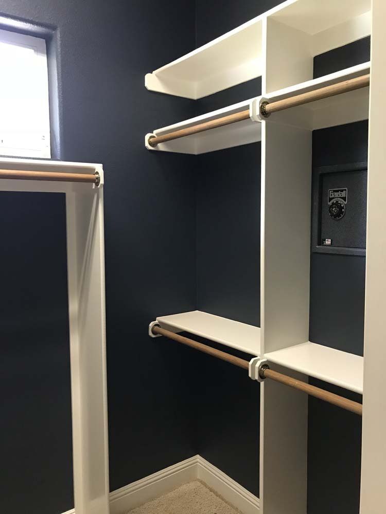 A walk in closet with a safe in the corner.