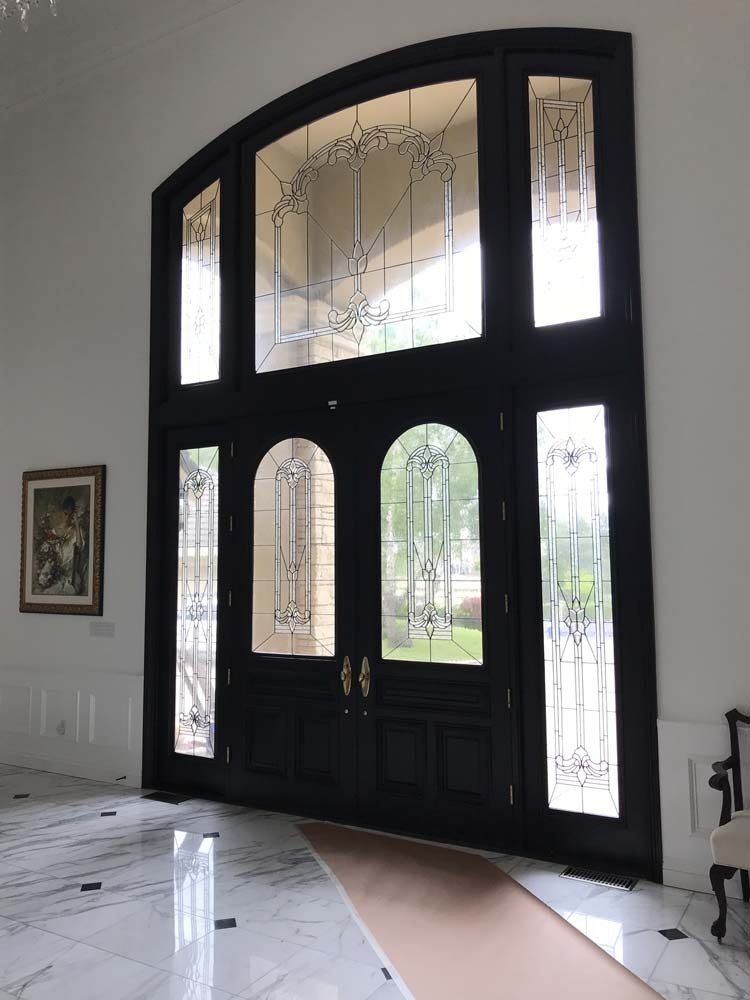 A large black door with a stained glass window
