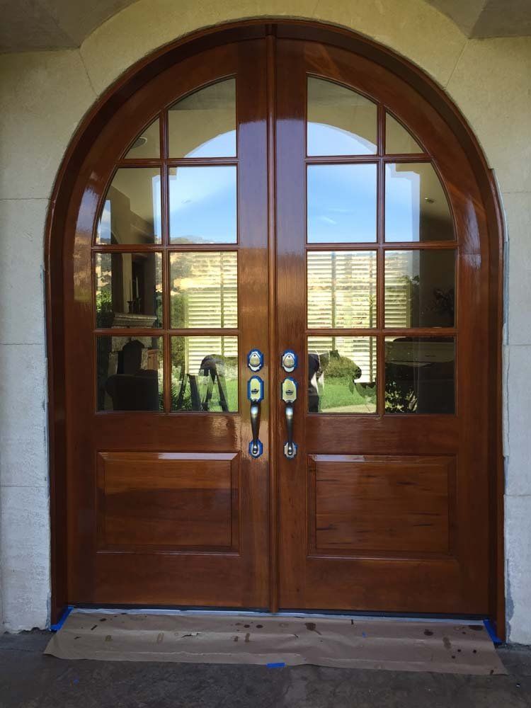 A pair of arched wooden doors with lots of windows