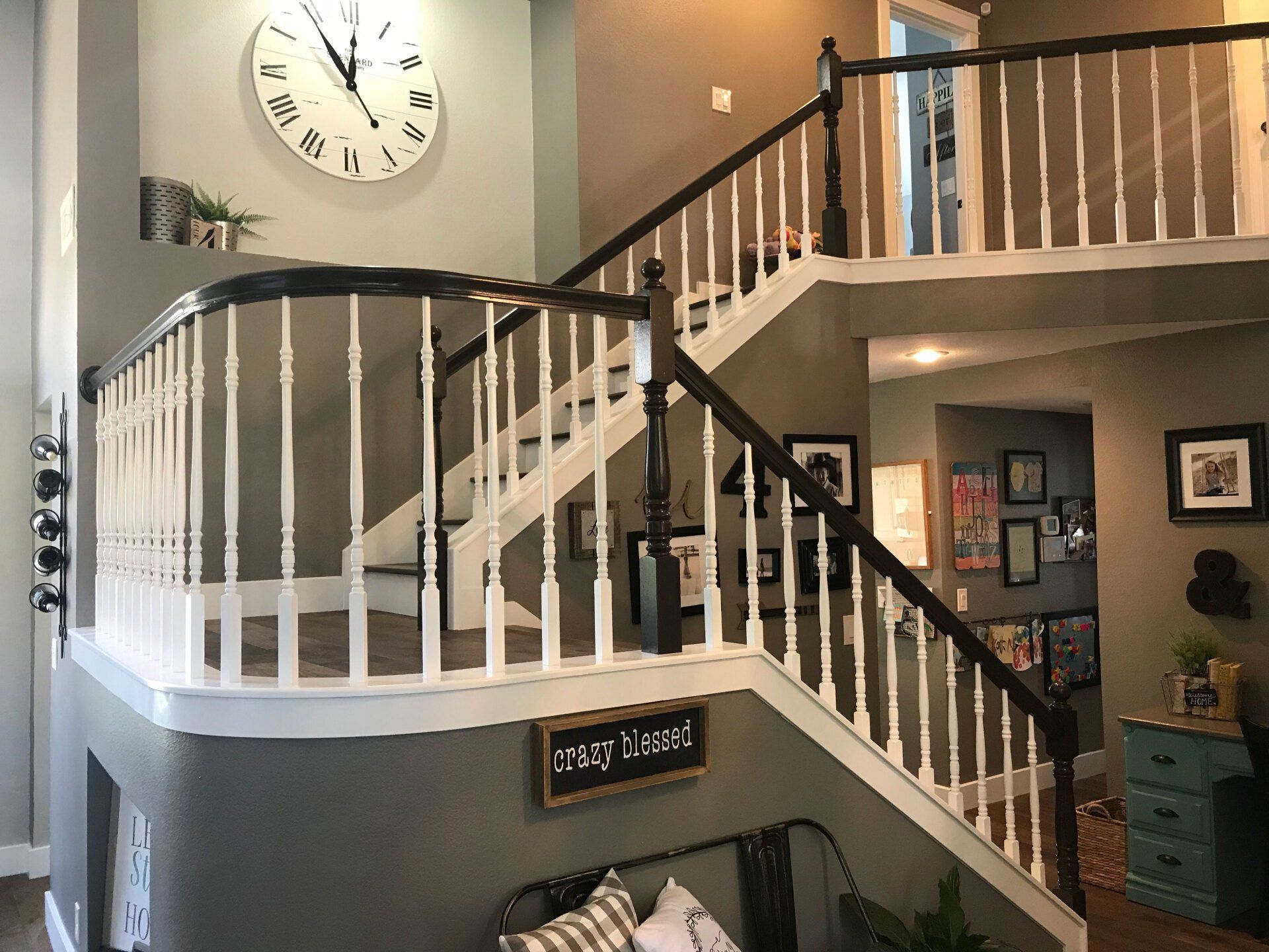 A staircase in a house with a clock on the wall above it.