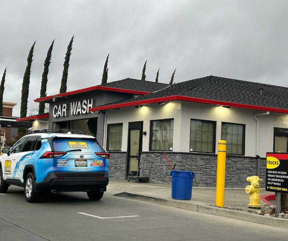 A car is parked in front of a car wash.