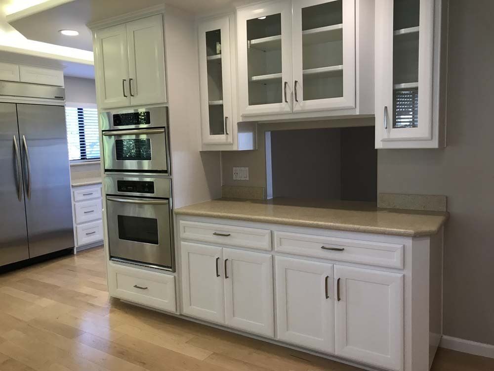 A kitchen with white cabinets and stainless steel appliances
