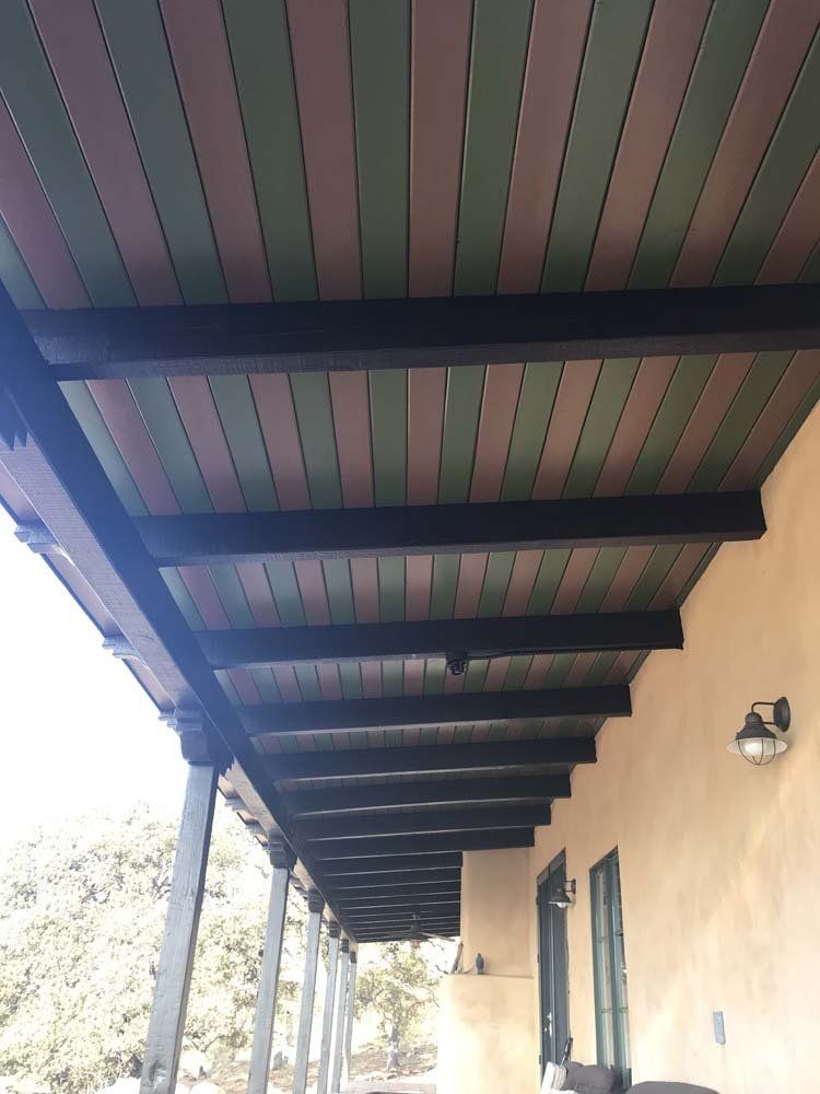 A porch with a wooden ceiling and beams