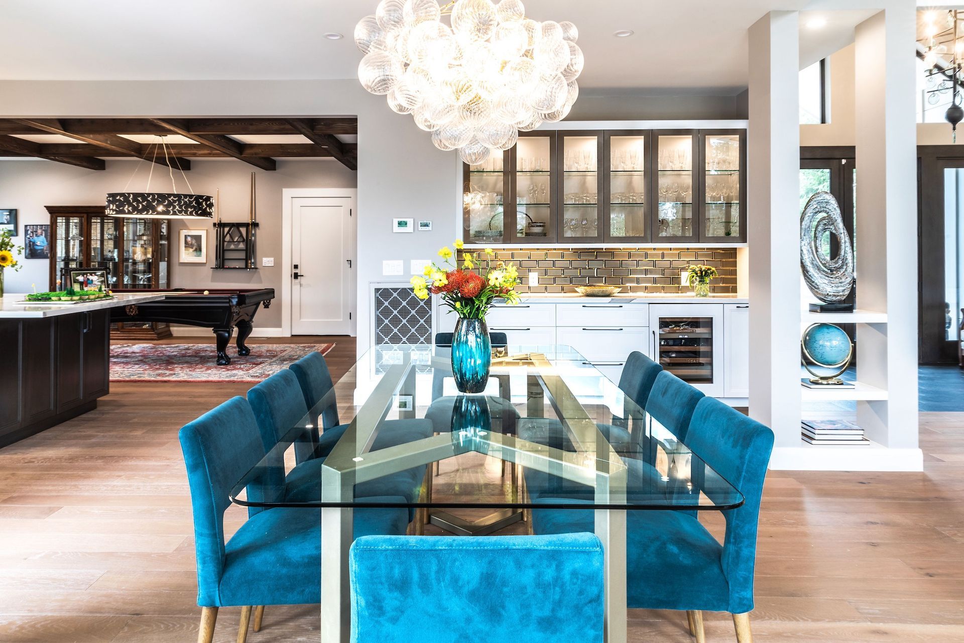 A dining room with a glass table and blue chairs