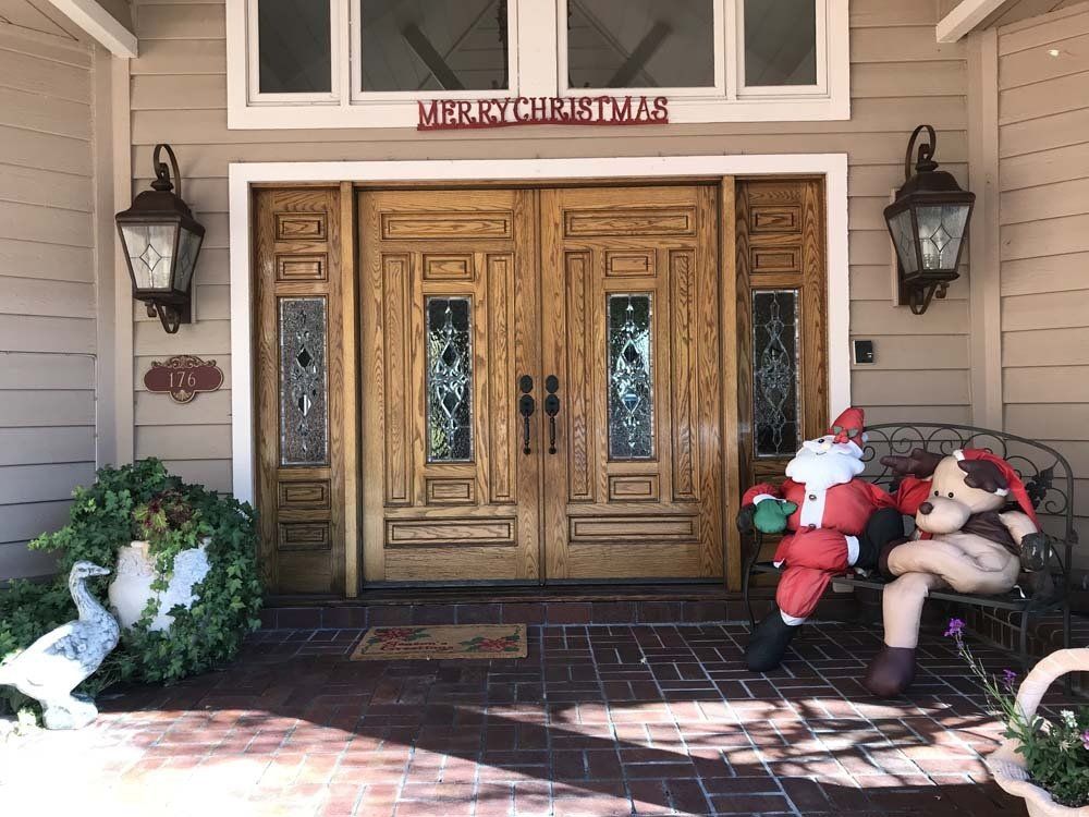 A large wooden door with a merry christmas sign above it