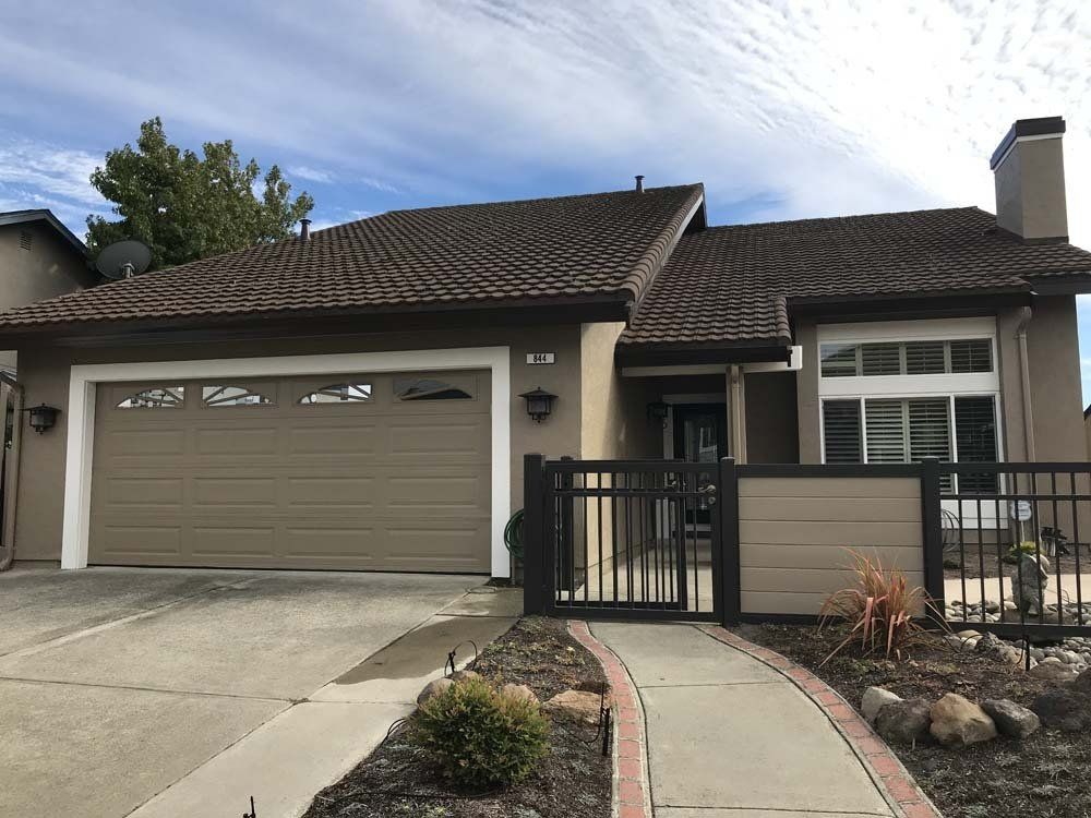 A house with two garage doors and a walkway leading to it