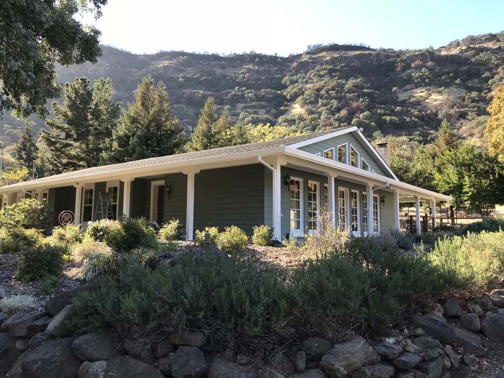 A house with a porch and a mountain in the background