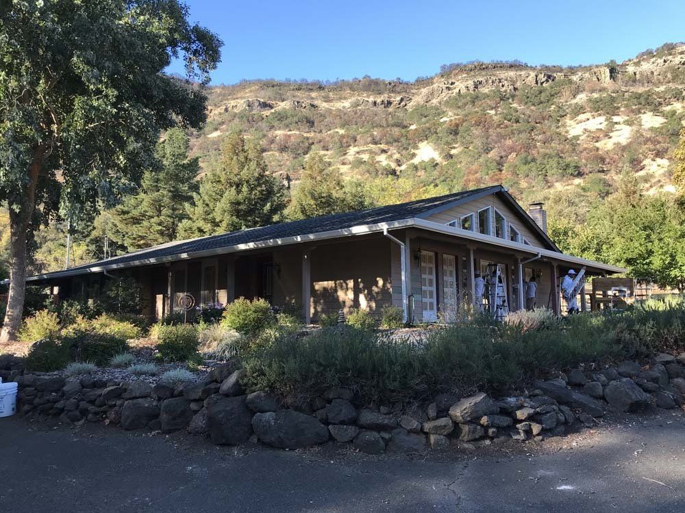 A large house with a porch and a mountain in the background
