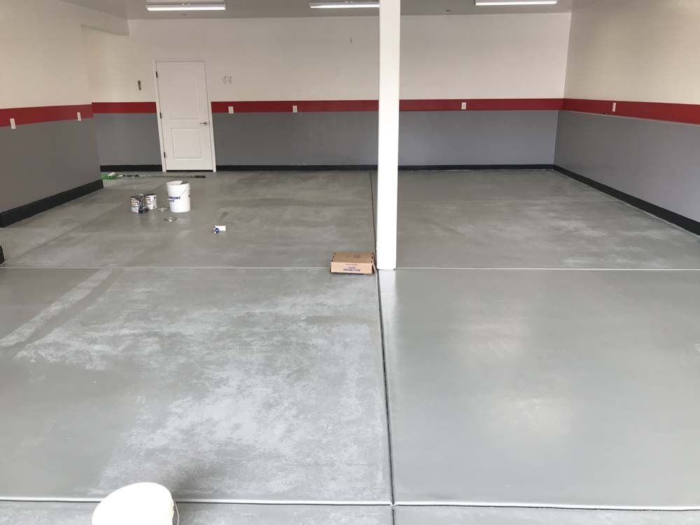 A large empty garage with a concrete floor and walls.