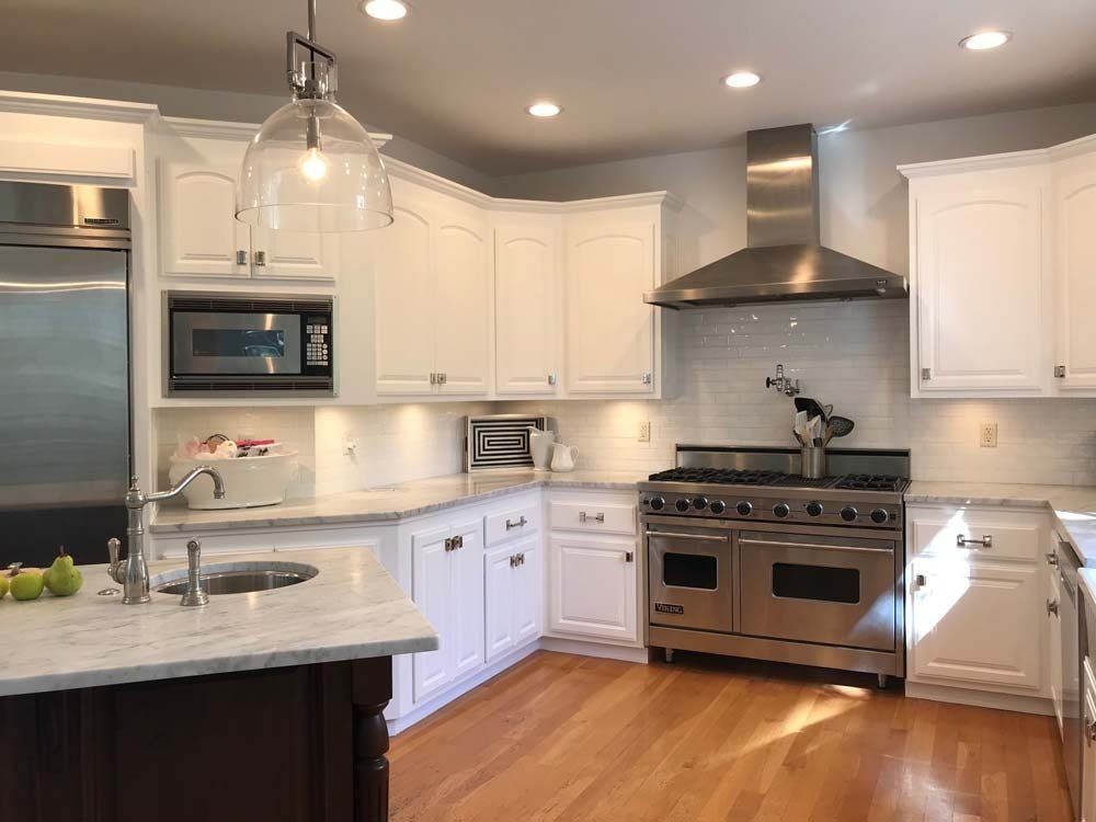 A kitchen with white cabinets and stainless steel appliances