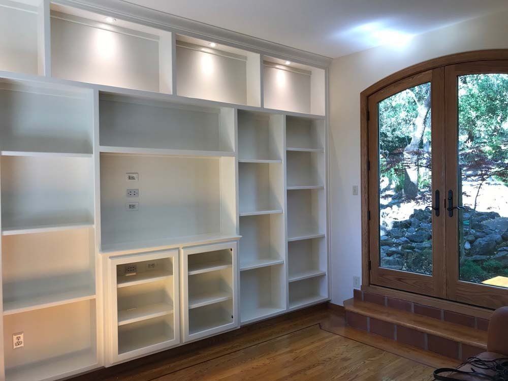 A room with a lot of shelves and a window