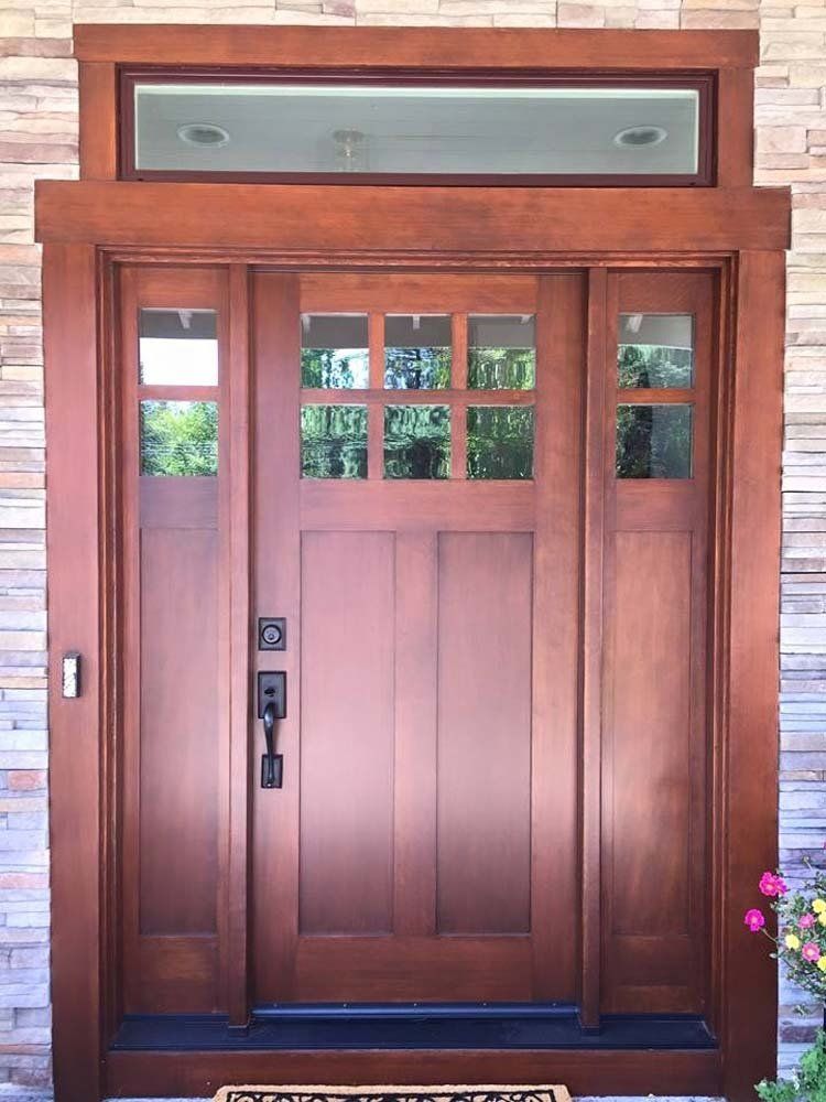 A large wooden door with a welcome mat in front of it