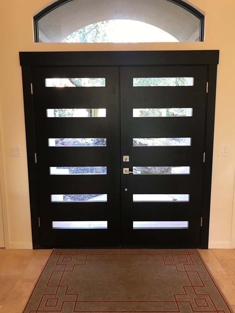 A black door with a rug in front of it