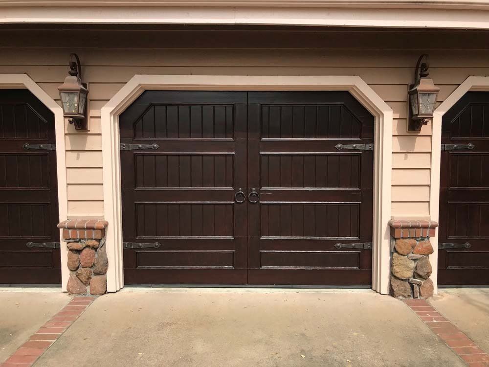 A row of brown garage doors on a house