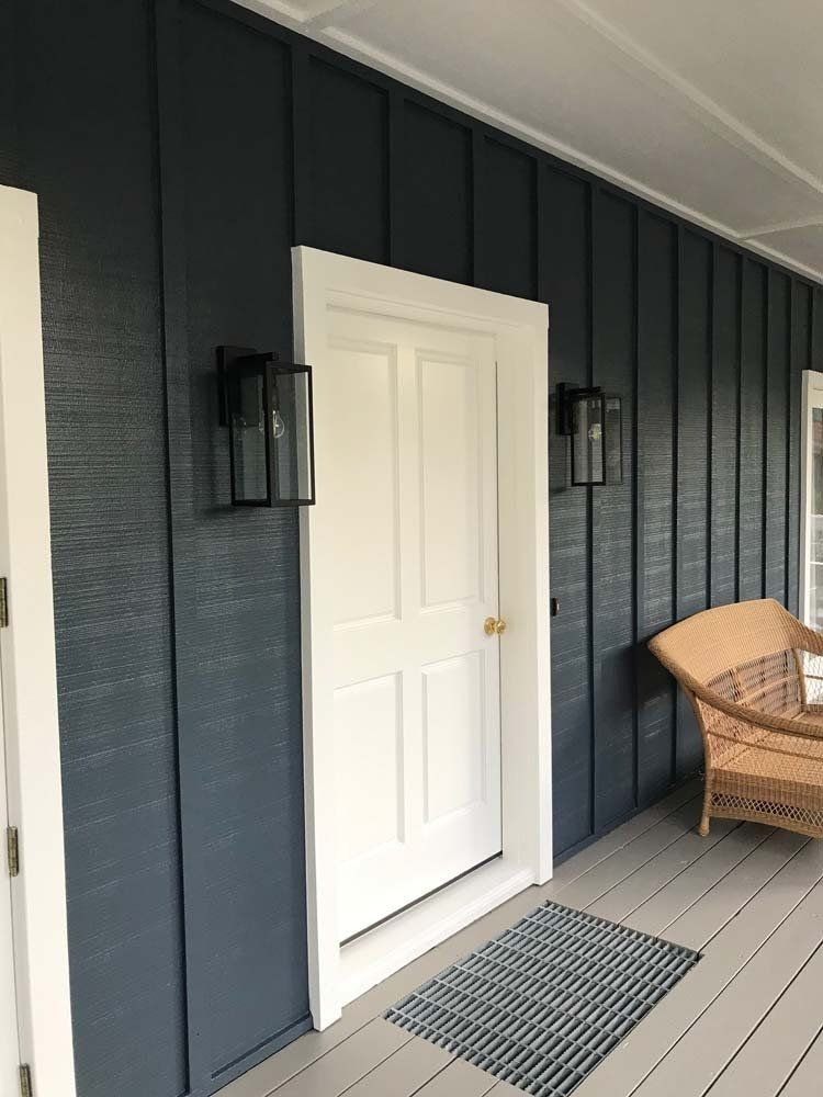 A porch with a wicker chair and a door