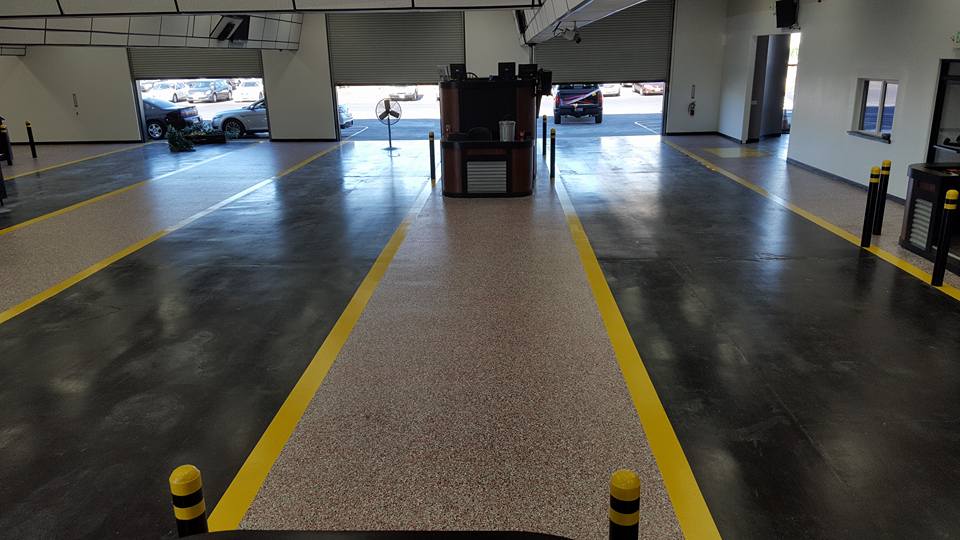 A large empty garage with yellow lines on the floor.