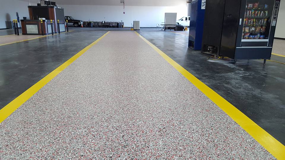 A garage with a yellow line on the floor and a vending machine.