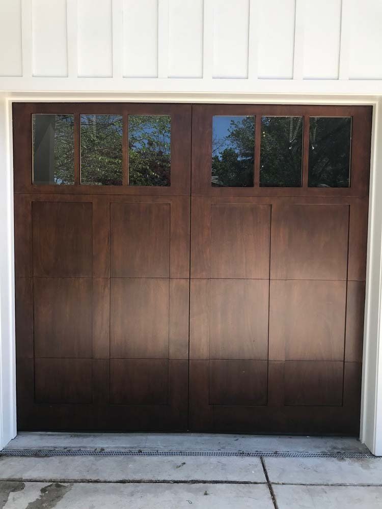 A close up of a wooden garage door with a window.