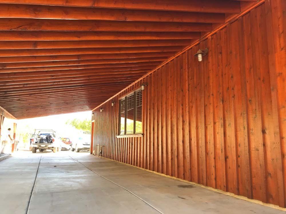 A wooden building with a car parked underneath it.