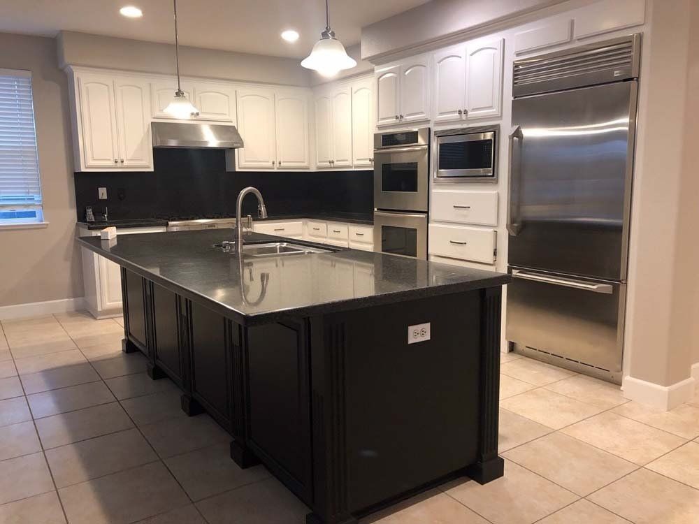 A kitchen with a large island and stainless steel appliances