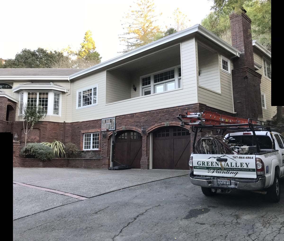 A truck is parked in front of a large house.