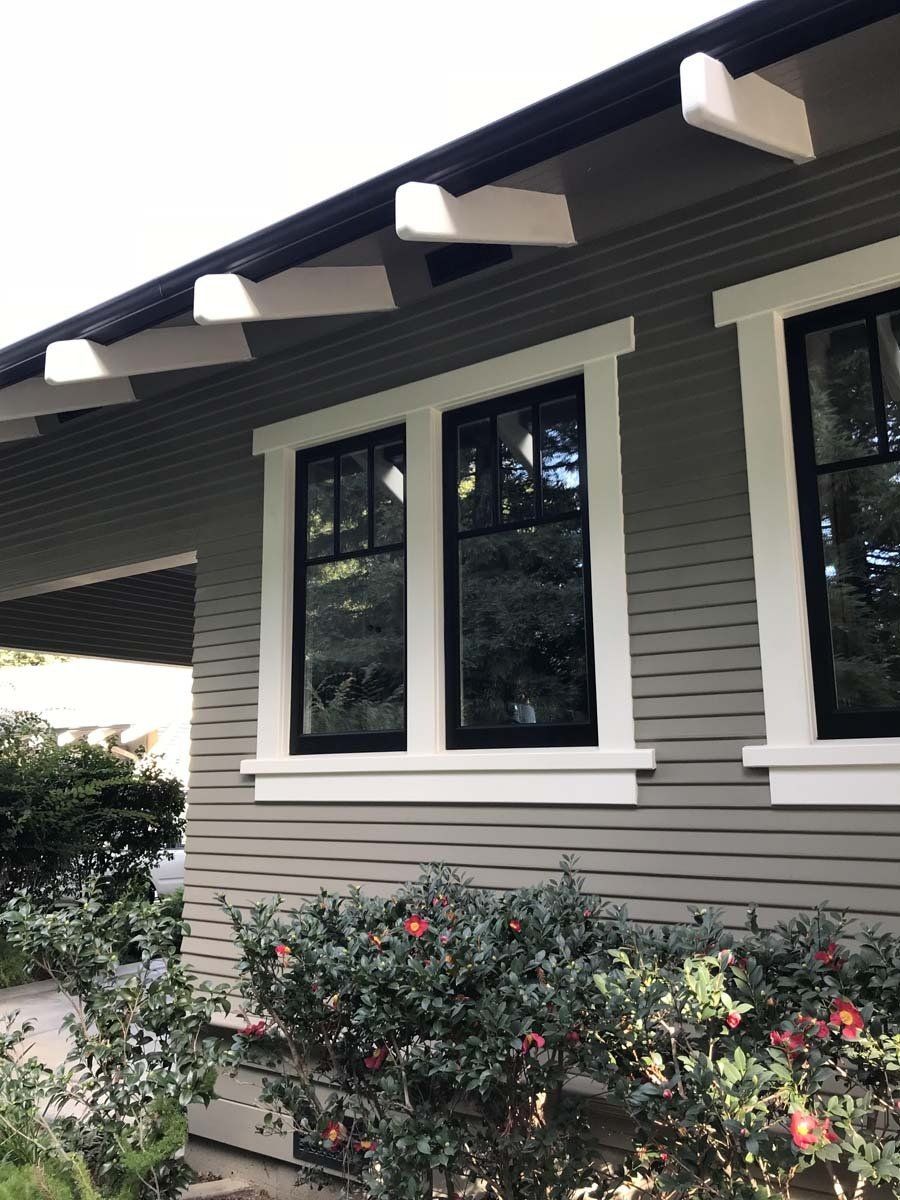 The front of a house with black windows and white trim.