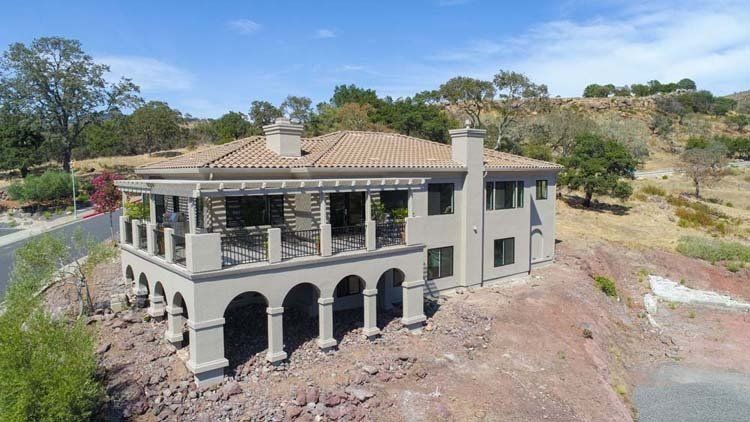 An aerial view of a large house on top of a hill.