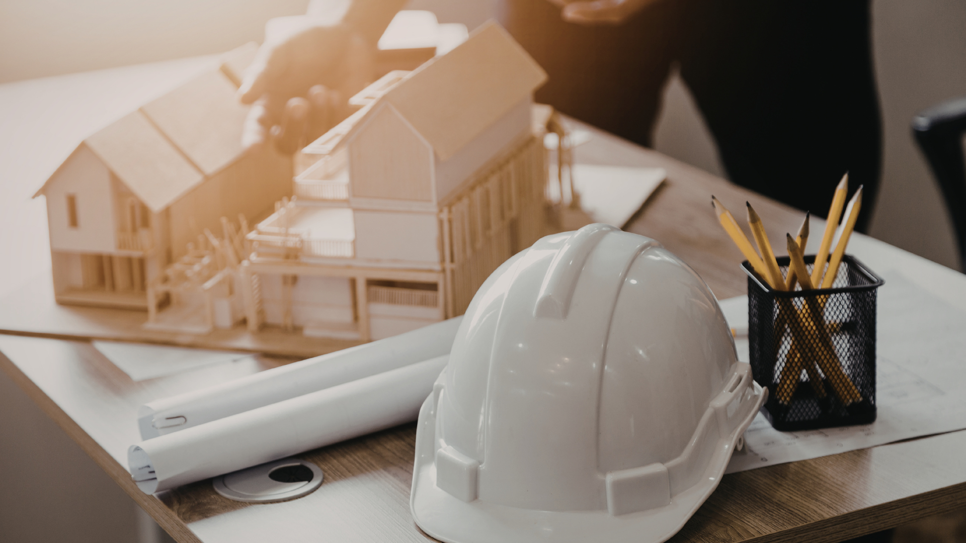 Modern home with a dark gray exterior, large windows, and a sloping roof, set in a wooded area.