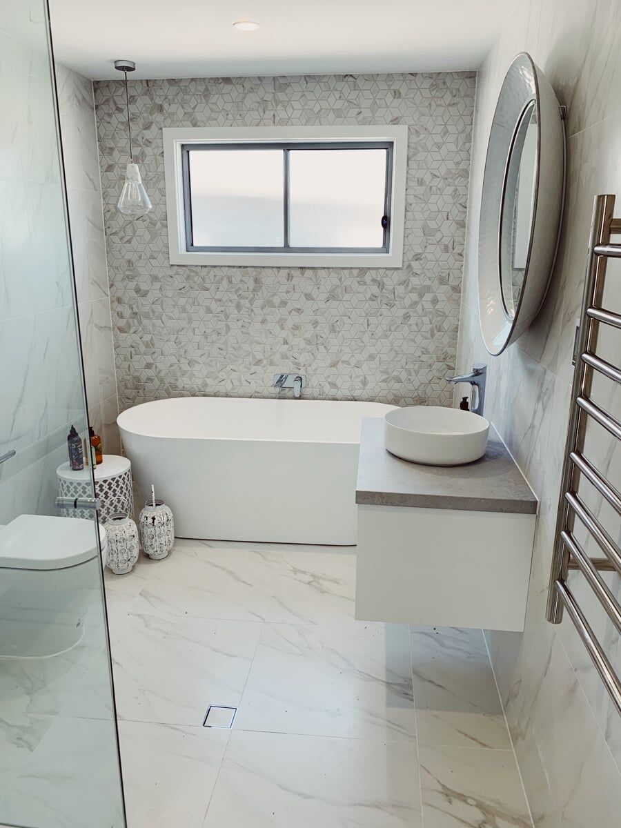 A Bathroom with a tub, sink, Toilet and Mirror — Illawarra Bathrooms in Wollongong, NSW