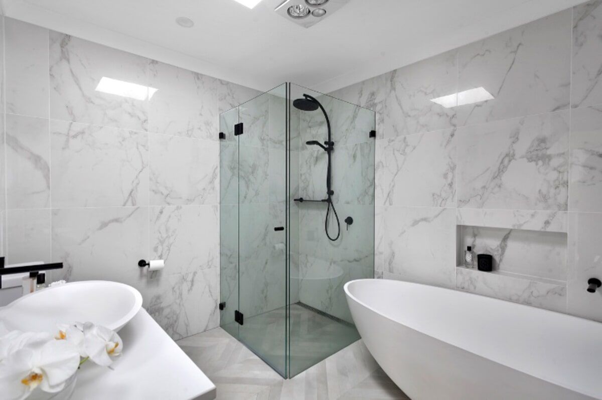 A Bathroom with a Bathtub, Sink, Shower and Marble Walls — Illawarra Bathrooms in Wollongong, NSW