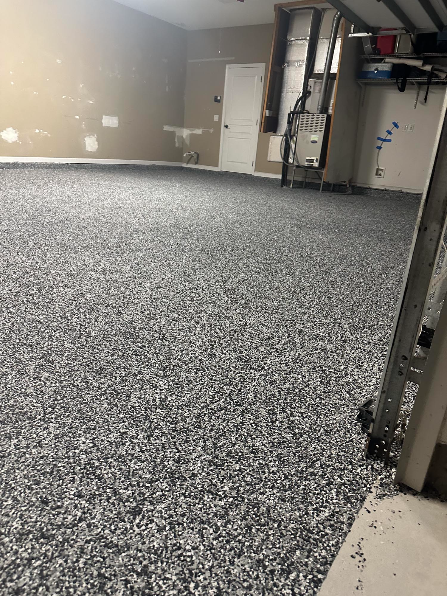 Gray epoxy floor with a partially visible wall and support column.