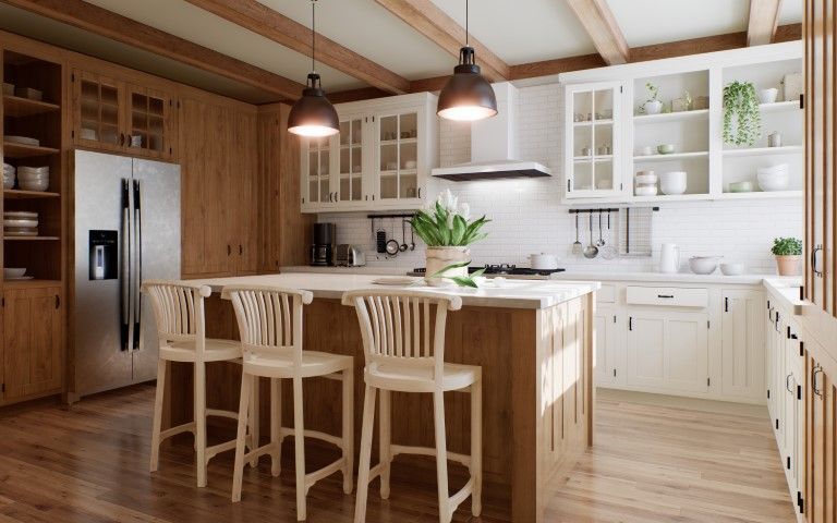A bright kitchen with light wooden cabinets, island, and bar stools. Includes stainless steel appliances and pendant lights.