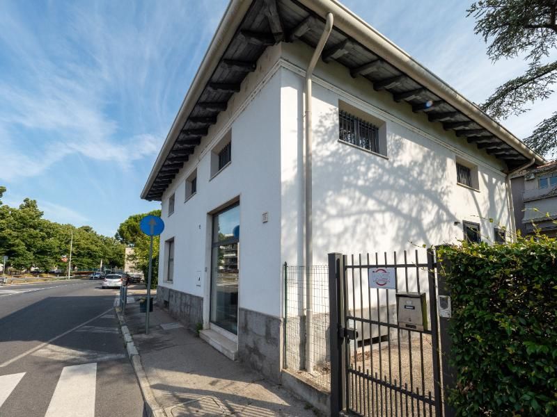 Un edificio bianco con una recinzione di fronte