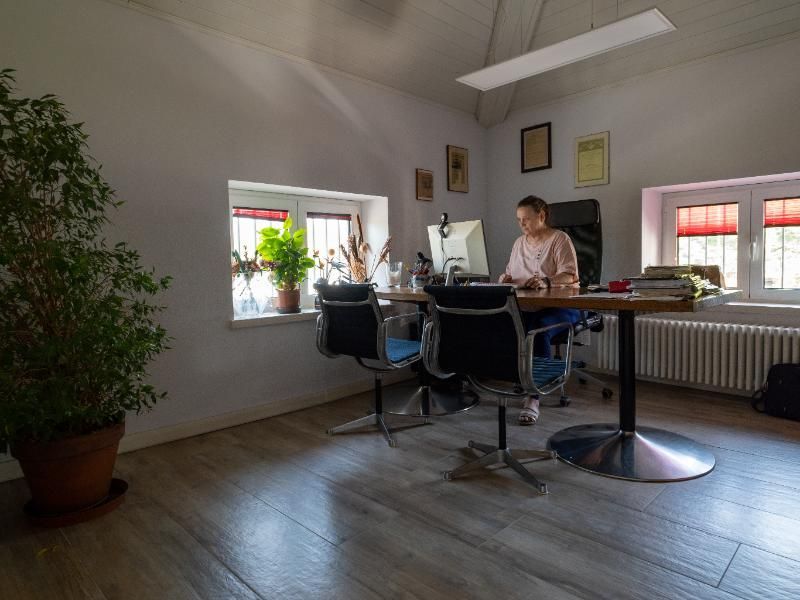 Una donna è seduta alla scrivania di un ufficio e usa un computer.