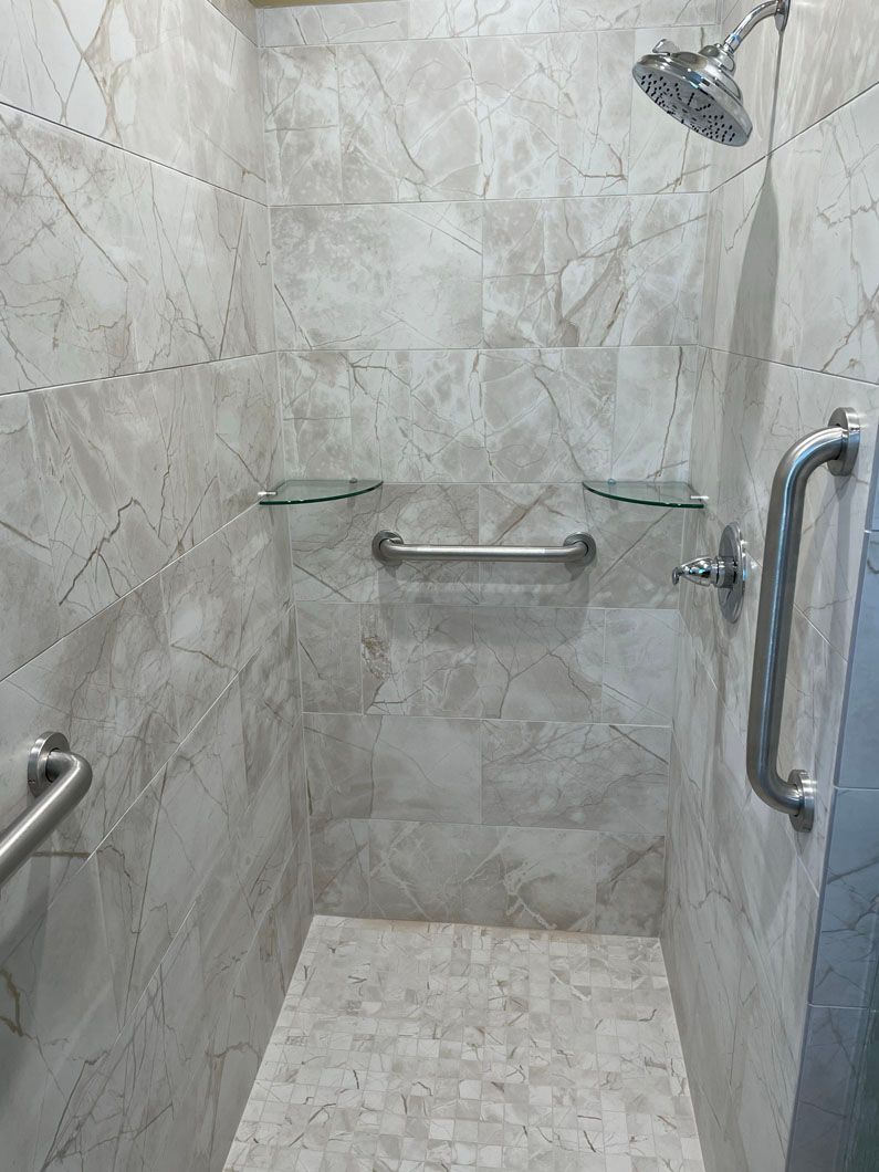 A bathroom with a walk in shower and a shower head.