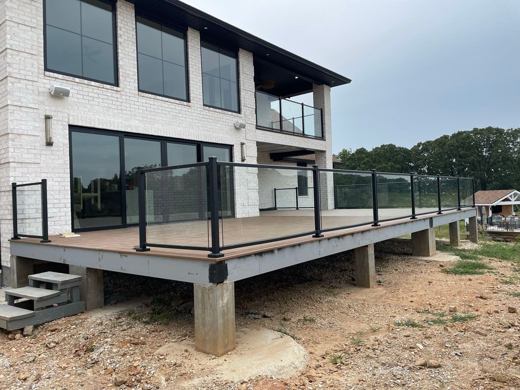 A large house with a large deck and a glass railing.