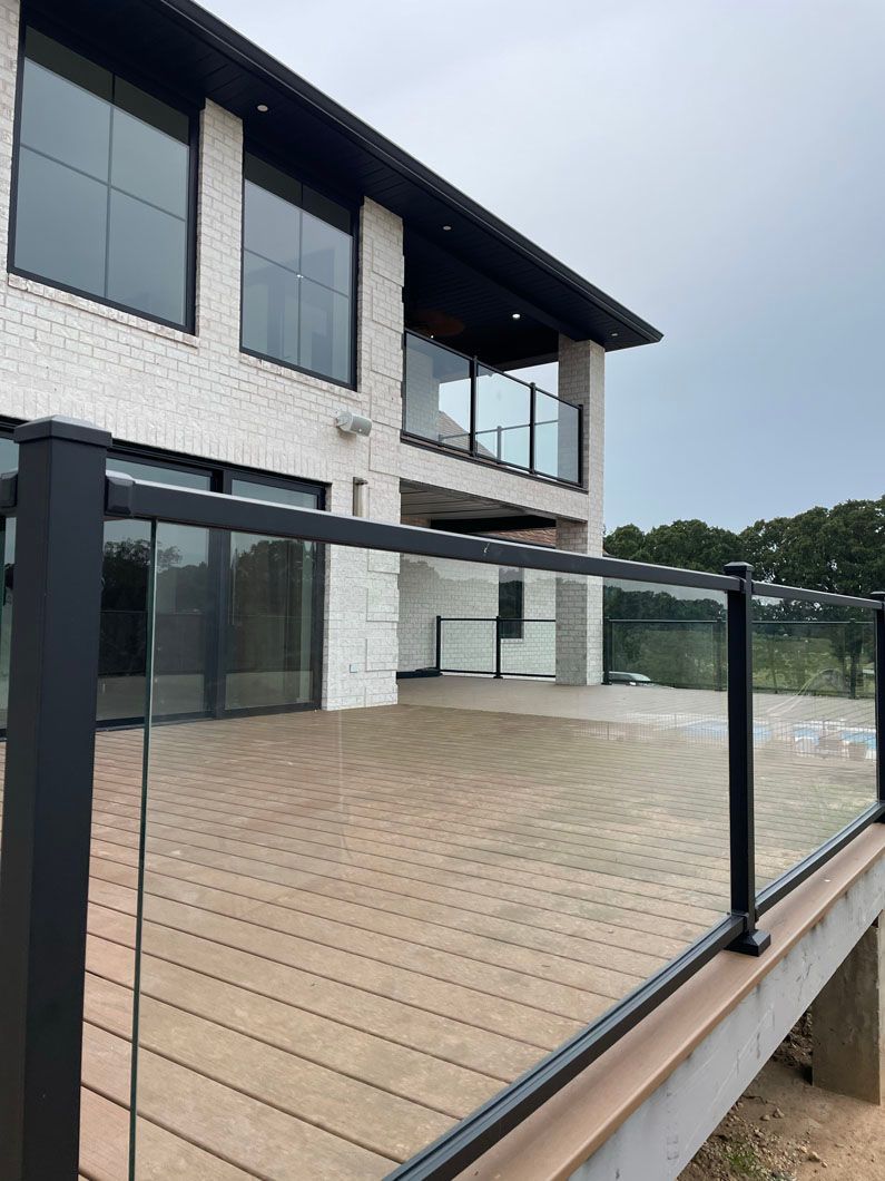 A large house with a large deck and a glass railing.