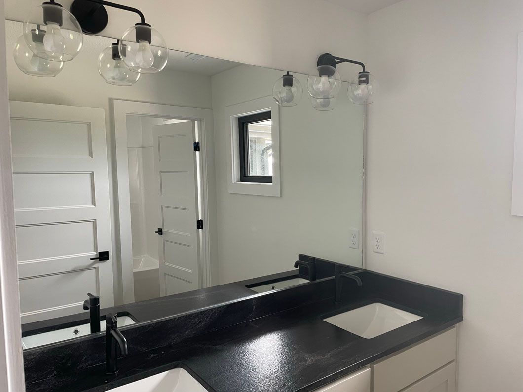 A bathroom with two sinks and a large mirror.