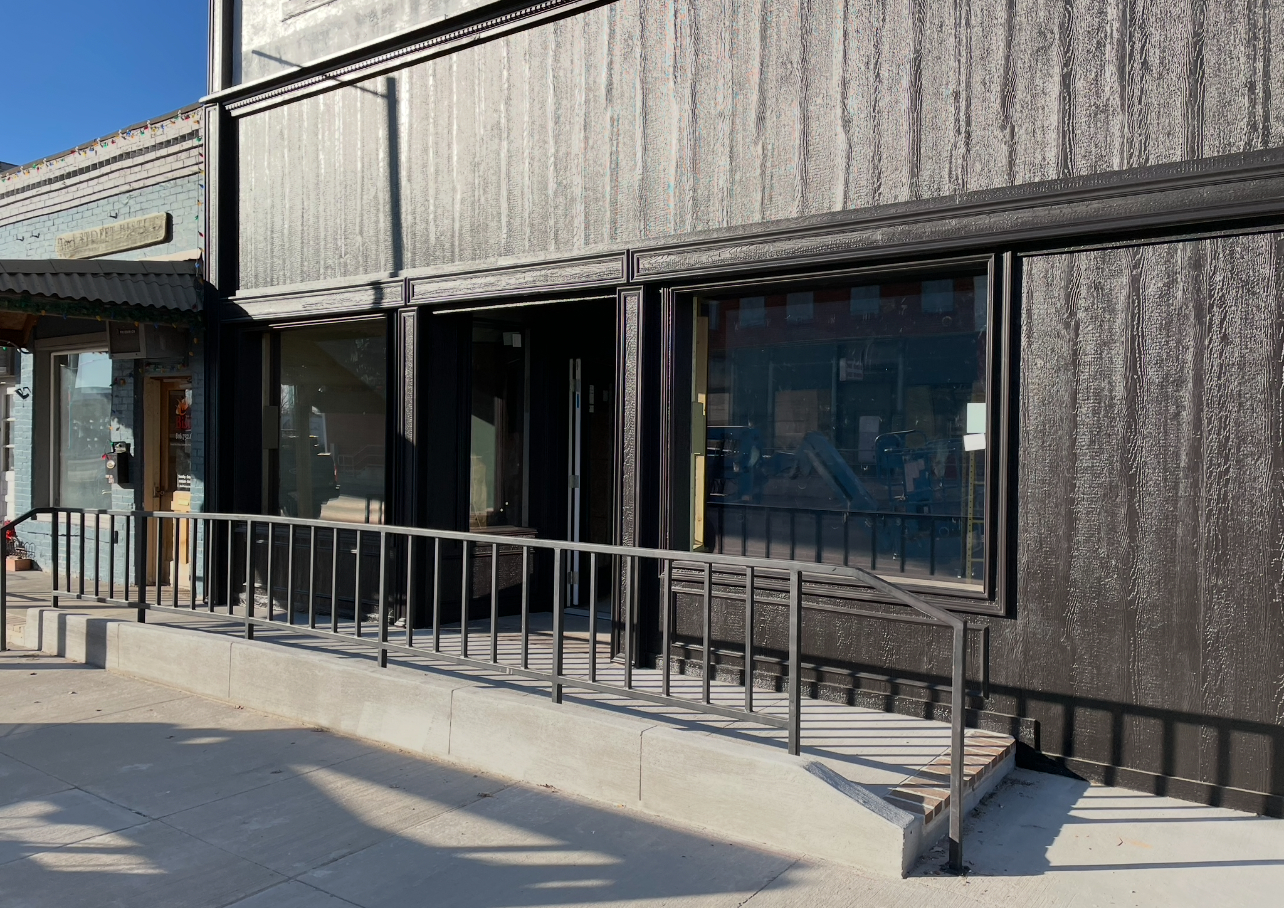 A building with a ramp and a bench in front of it.