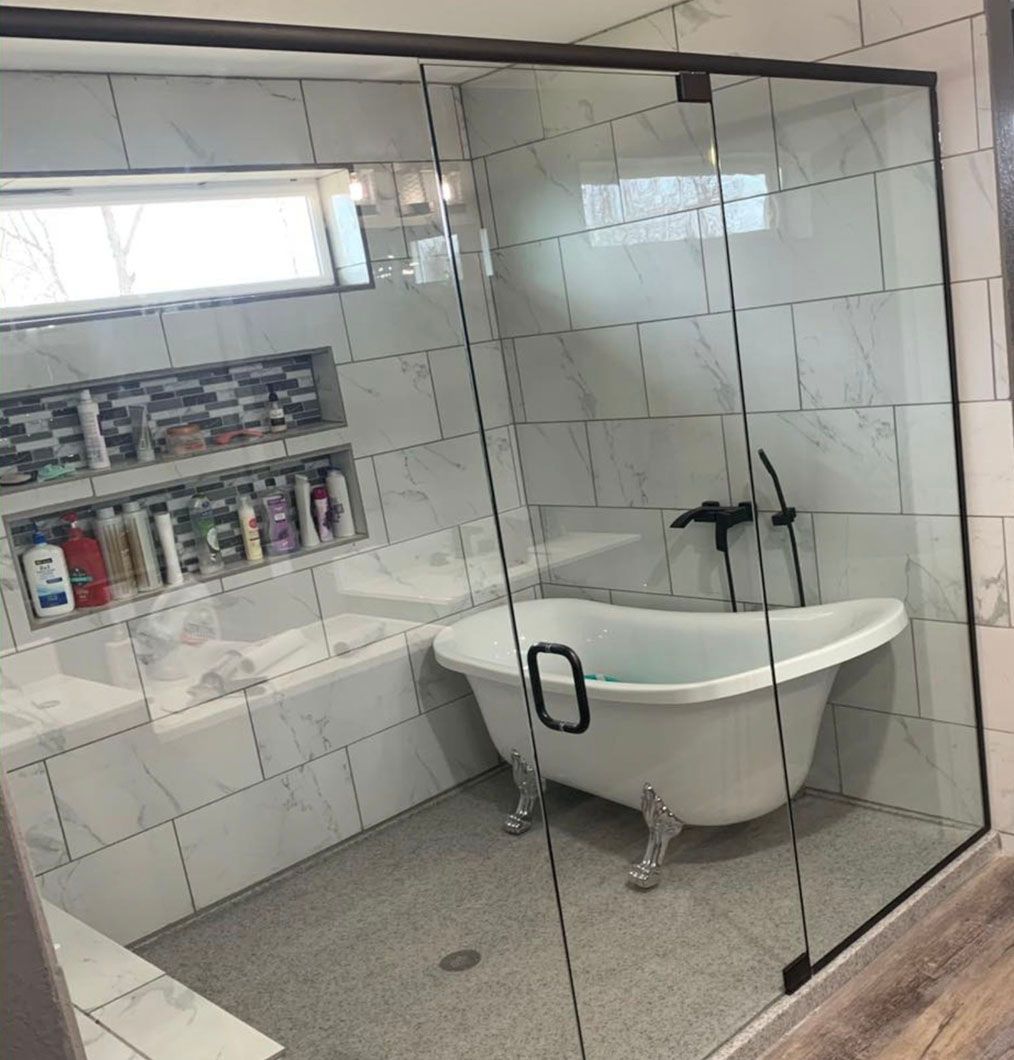 A bathroom with a claw foot tub and a glass shower door.