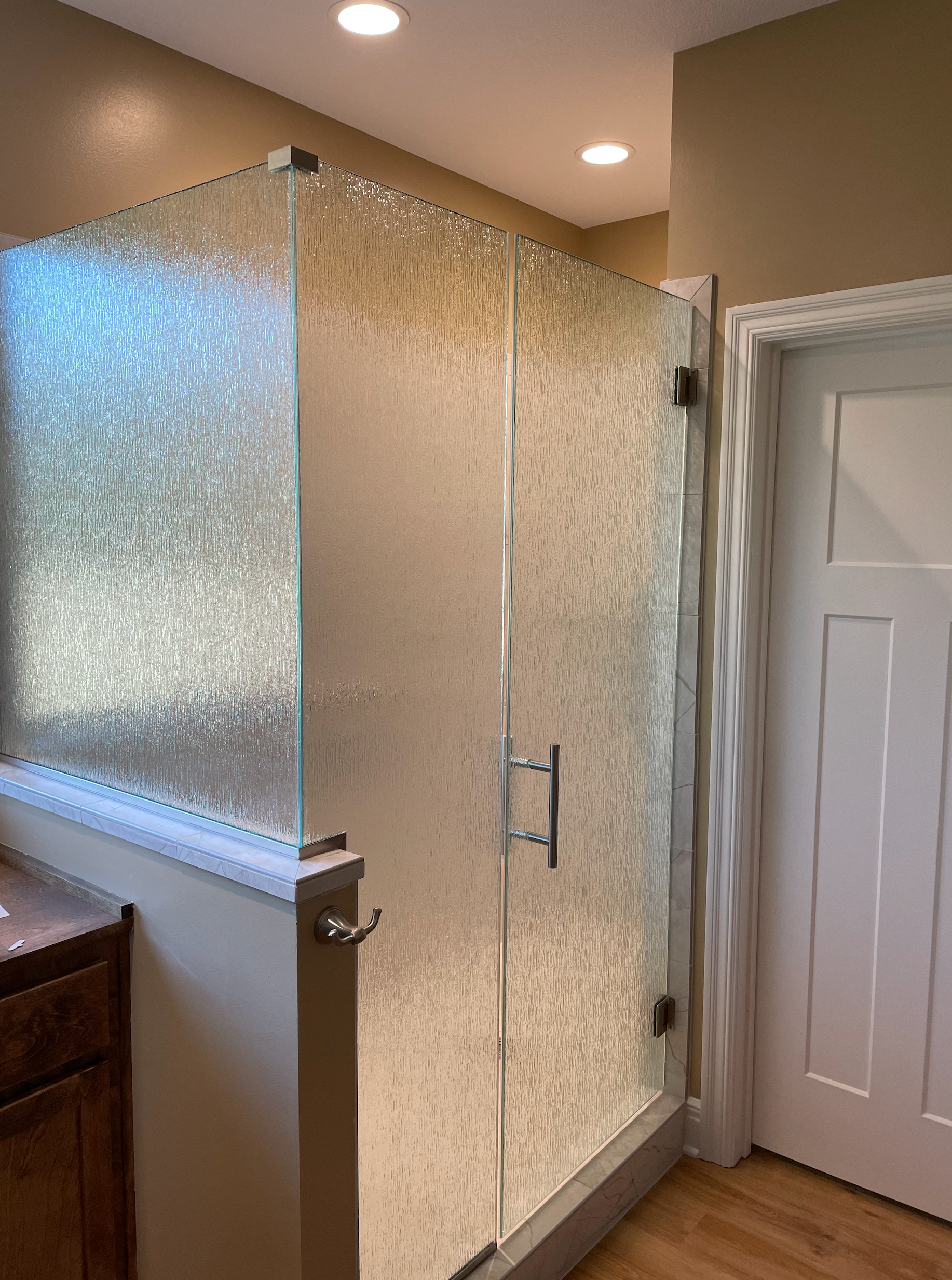 A bathroom with a walk in shower and a door.