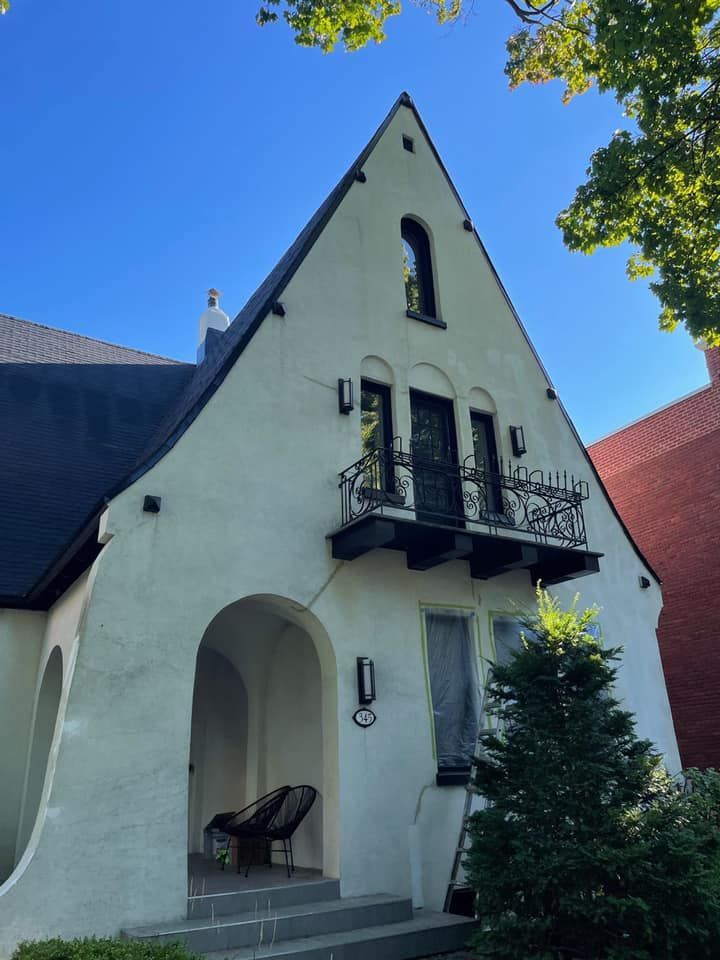 une maison blanche avec un balcon au sommet